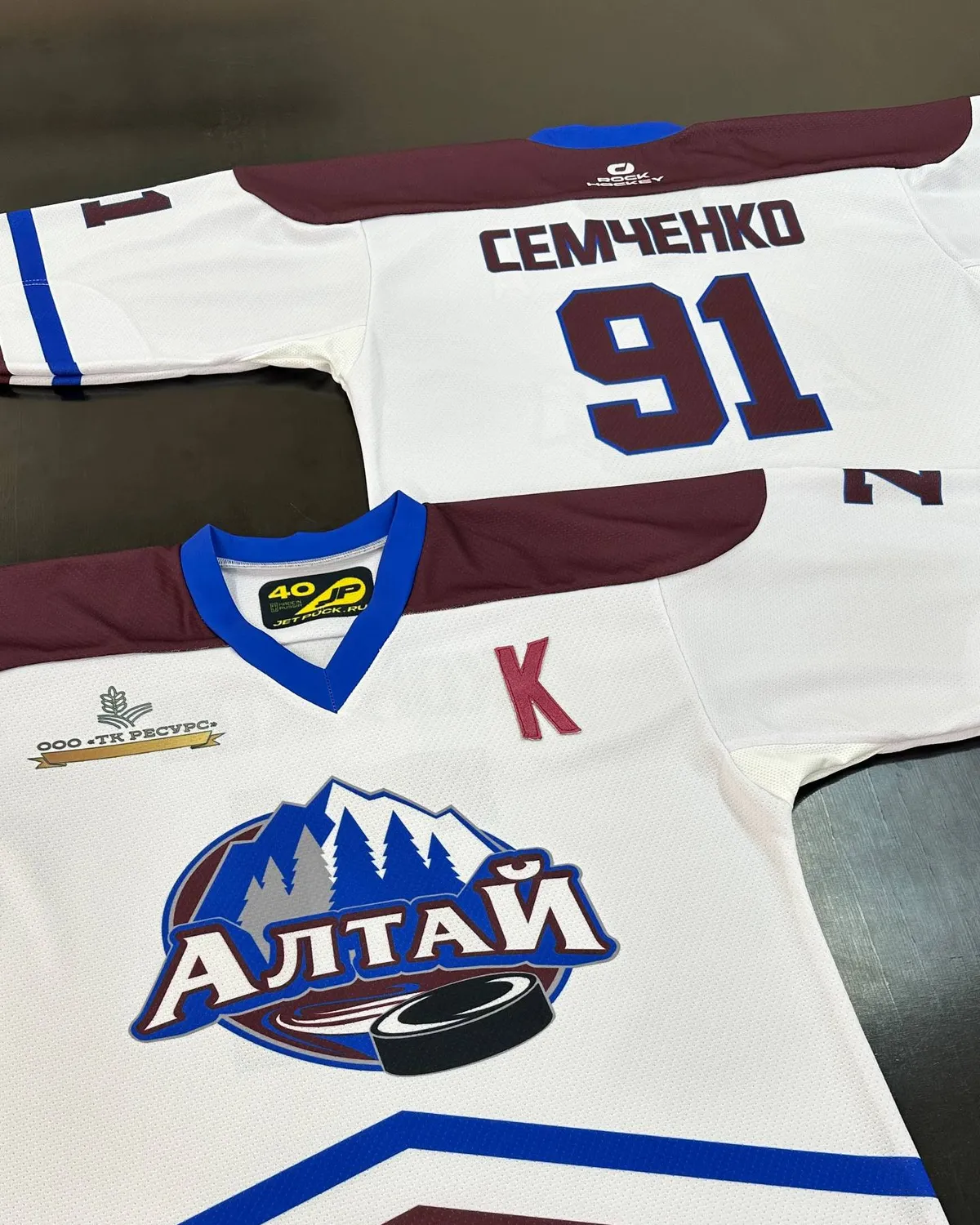Белая форма «Алтай» на столе, тот же дизайн, с логотипом клуба и спонсора